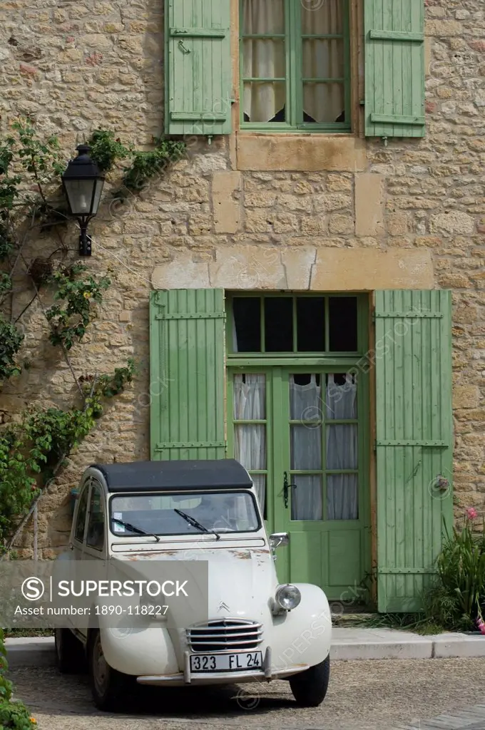An old Deux Chevaux car parked in front of an old village house, Dordogne, France, Europe