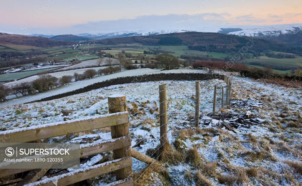 Snow dusted fence and fields looking towards Bwlch and snowy mountains beyond, Brecon Beacons National Park, Powys, Wales, United Kingdom, Europe