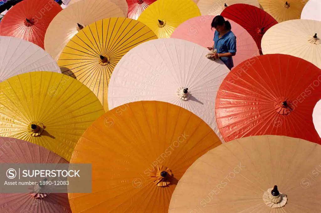 Woman finishing painted umbrellas in a village near Chiang Mai, Thailand, Southeast Asia, Asia