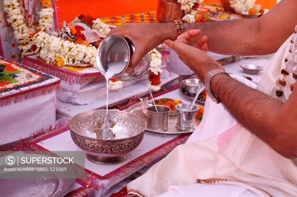 Bathing a statue of the goddess Durga with milk during Puja in a Hindu temple, Haridwar, India, Asia