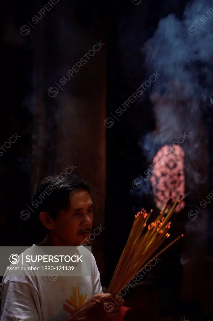 Man with joss sticks, Hue, Vietnam, Indochina, Southeast Asia, Asia