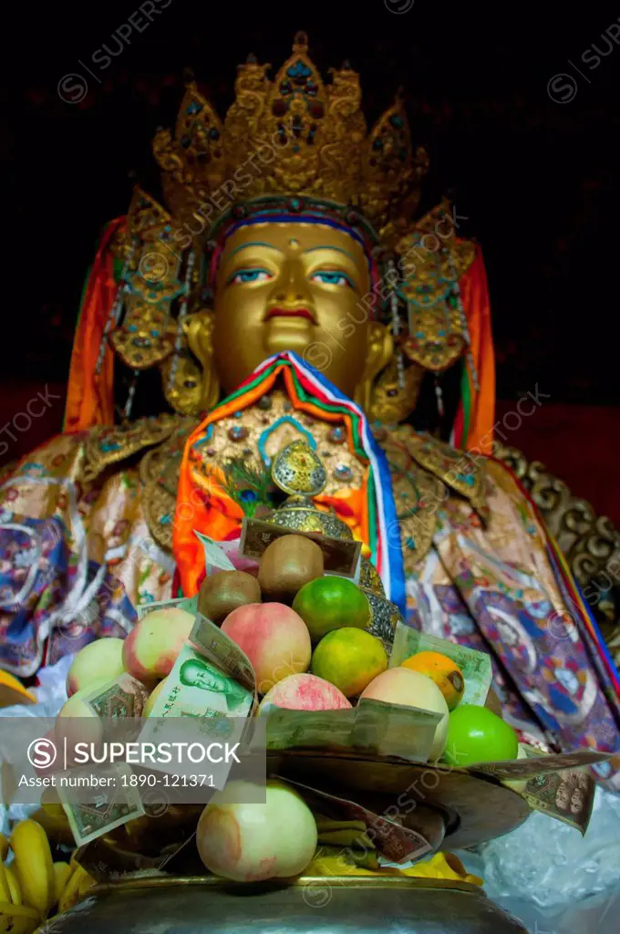 Buddha with sacrifical offerings in a little temple in Lhasa, Tibet, China, Asia