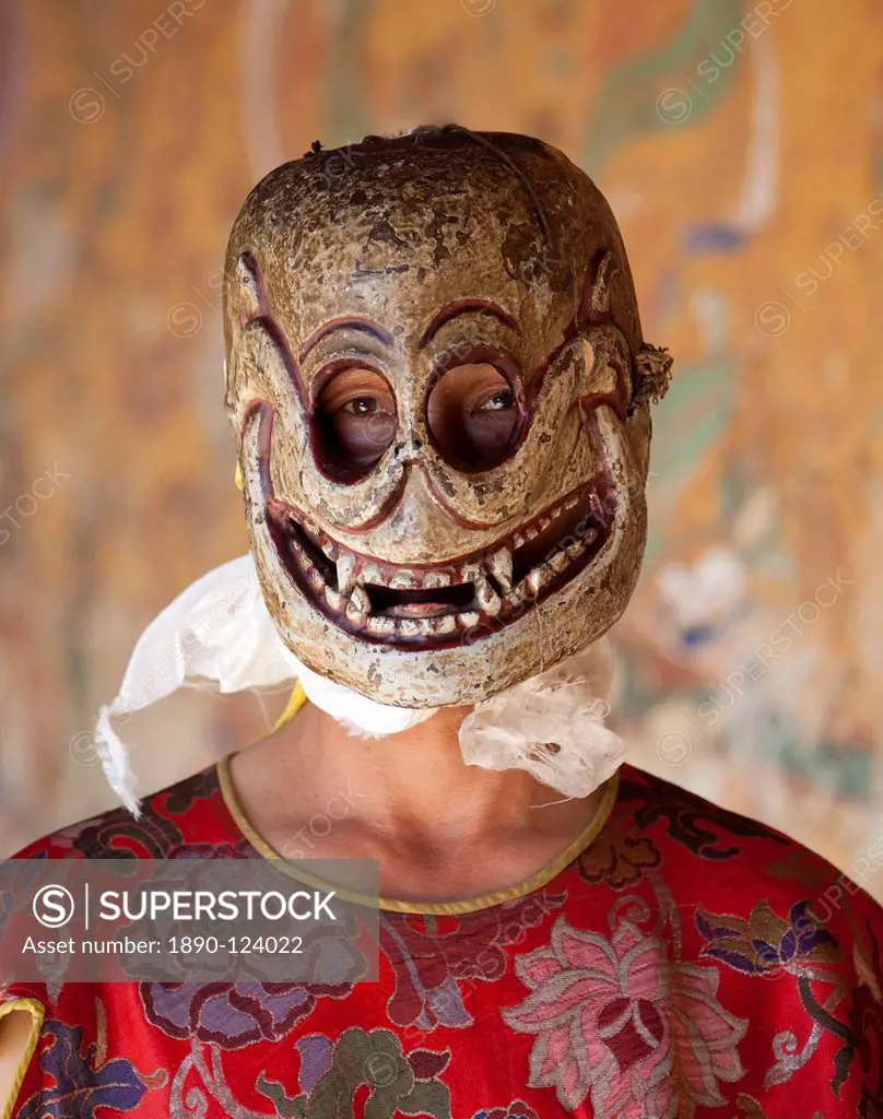 Buddhist monk wearing carved wooden mask in the shape of a skull preparing to take part in traditional dance performance at the Tamshing Phala Choepa ...