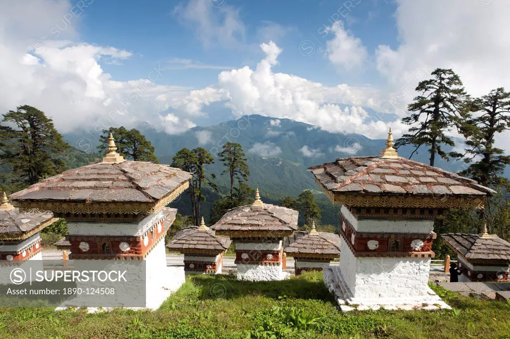 Some of the 108 Chortens located at the summit of the Dochu La Pass with views towards distant forested mountains between Thimpu and Punakha, Bhutan, ...