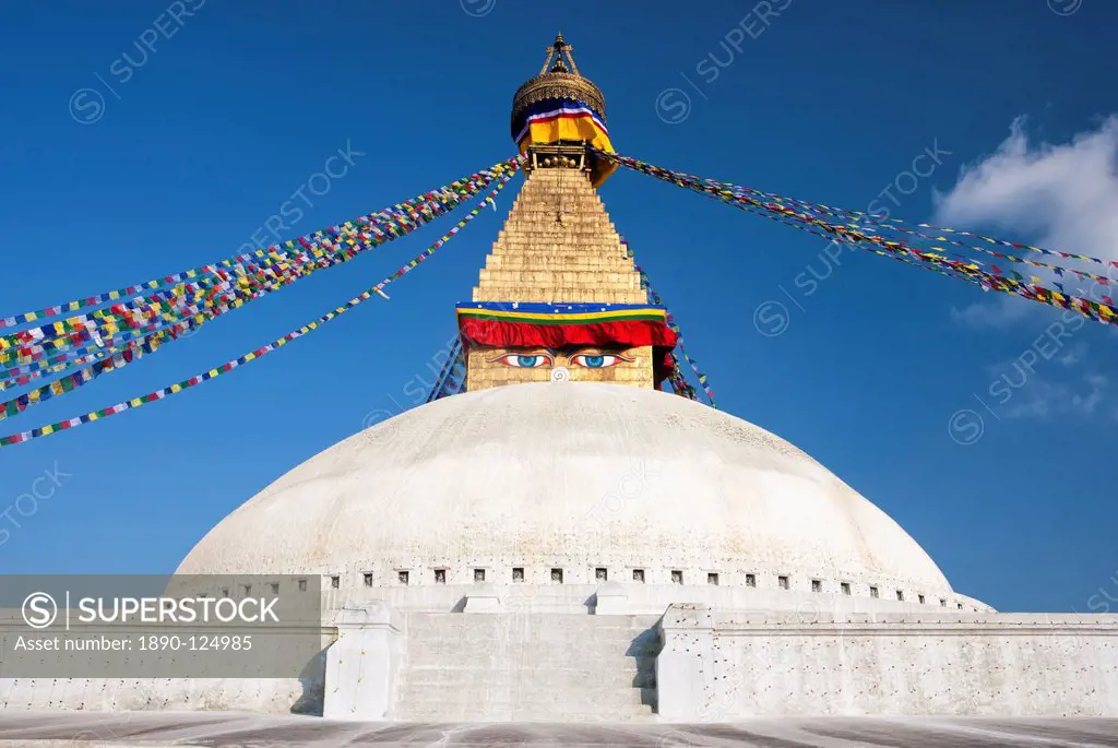 Bodhnath Stupa Boudhanth Boudha, one of the holiest Buddhist sites in Kathmandu, UNESCO World Heritage Site, with colourful prayer flags against blue ...