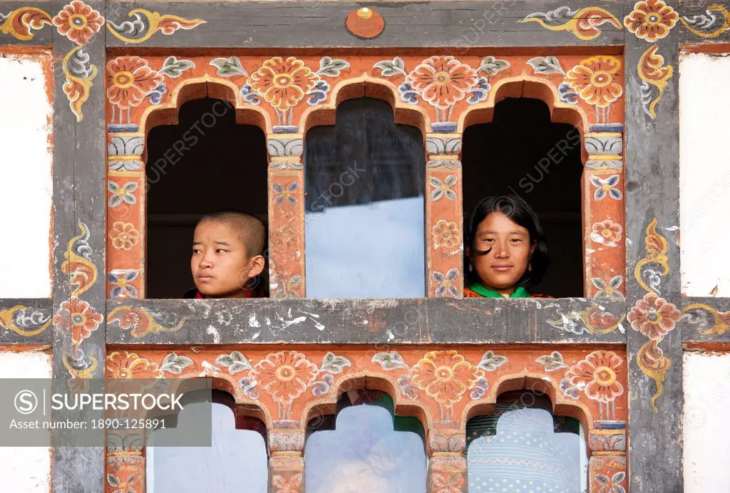 Girl and boy looking out of windows in room above the main courtyard of Wangdue Phodrang Dzong during Wangdue Phodrang Tsechu, Wangdue Phodrang Wangdi...