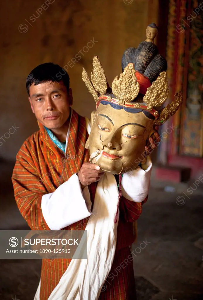 Local man holding an old golden mask with cracks visible in the face, Gangtey Tsechu at Gangte Goemba, Gangte, Phobjikha Valley, Bhutan, Asia