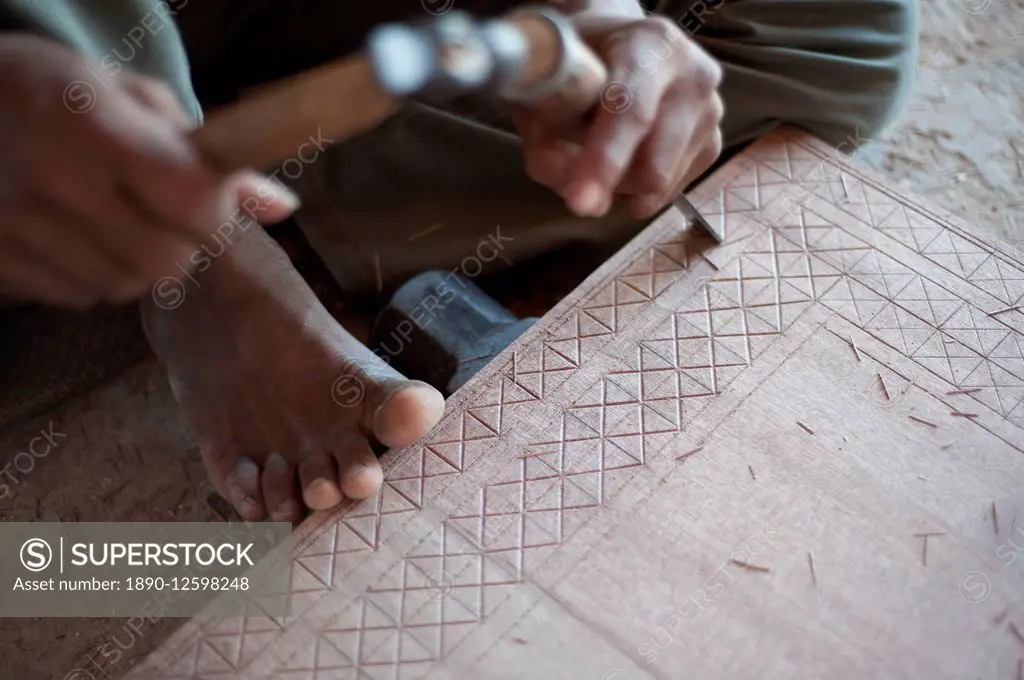 Carpenter chiselling traditional pattern in a piece of wood ready for varnished domestic furniture, Soyla, Kachchh (Kutch), Gujarat, India, Asia
