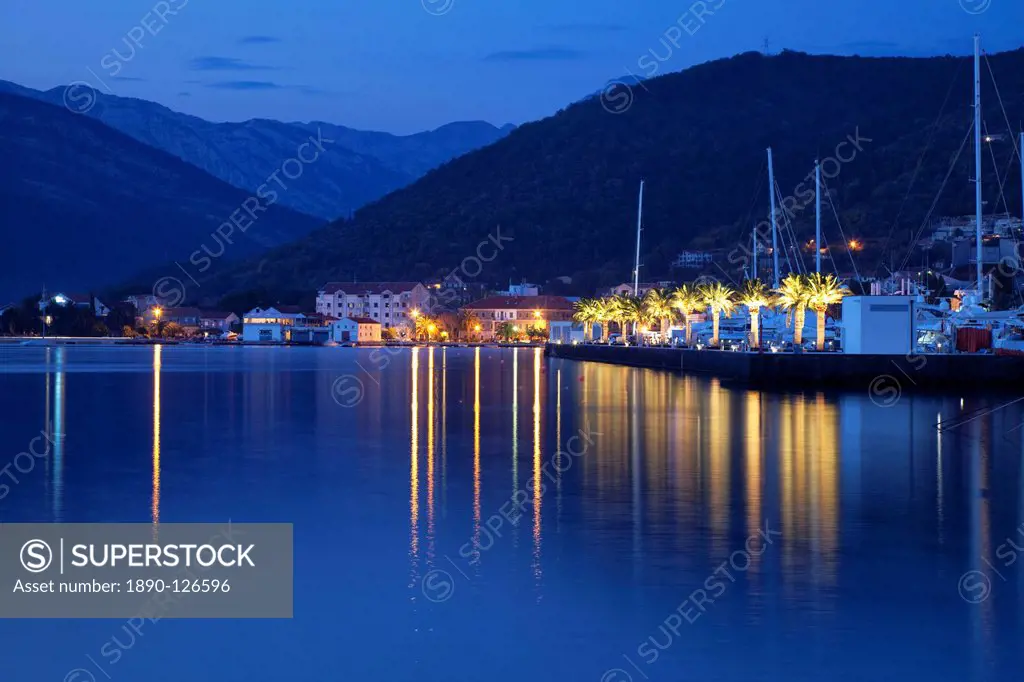 Waterfront at dusk at the newly developed Marina in Porto Montenegro with mountains behind, Montenegro, Europe