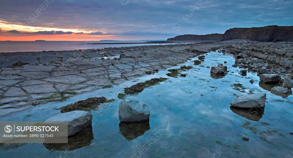 Sunrise over the Bristol Channel, in the foreground are the limestone ledges of Kilve beach, Somerset, England, United Kingdom, Europe