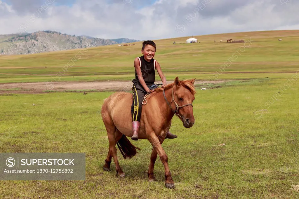 Horse and smiling boy riding bareback with ger and hills behind at summer nomad camp, Khujirt, Uvurkhangai (Ovorkhangai), Central Mongolia, Central As...