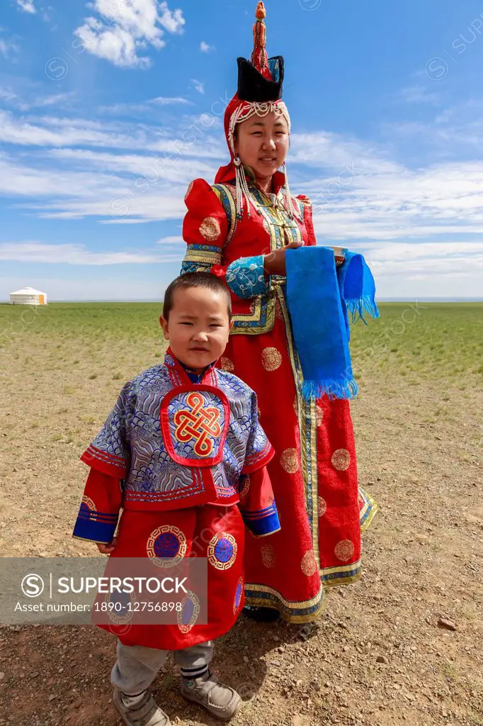 Woman and child in traditional dress (deel), silver bowl for milk greeting, near ger, Gobi desert, Bulgan, Omnogov, Mongolia, Central Asia, Asia