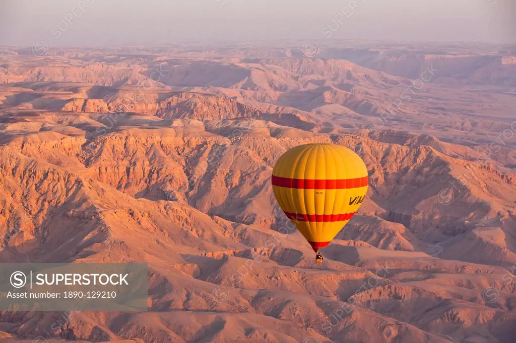 Hot air balloon suspended over the Theban hills of Luxor at sunrise, Thebes, Egypt, North Africa, Africa