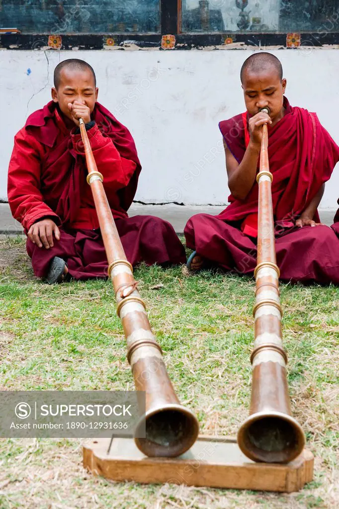 Monks playing Dungchen trumpet, Punakha, Bhutan, Asia