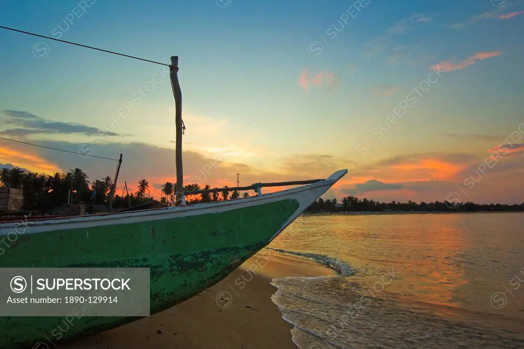 Outrigger boat at sunset at this fishing beach and popular tourist surf destination, Arugam Bay, Eastern Province, Sri Lanka, Asia