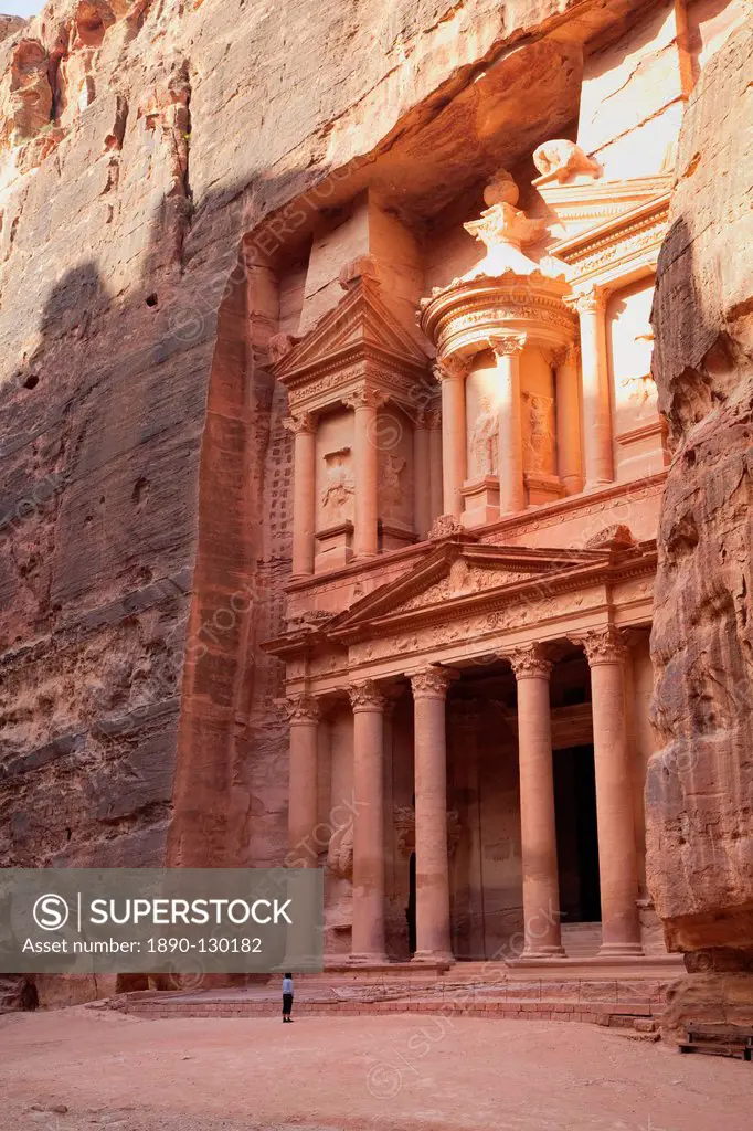 Tourist looking up at the facade of the Treasury Al Khazneh carved into the red rock at Petra, UNESCO World Heritage Site, Jordan, Middle East