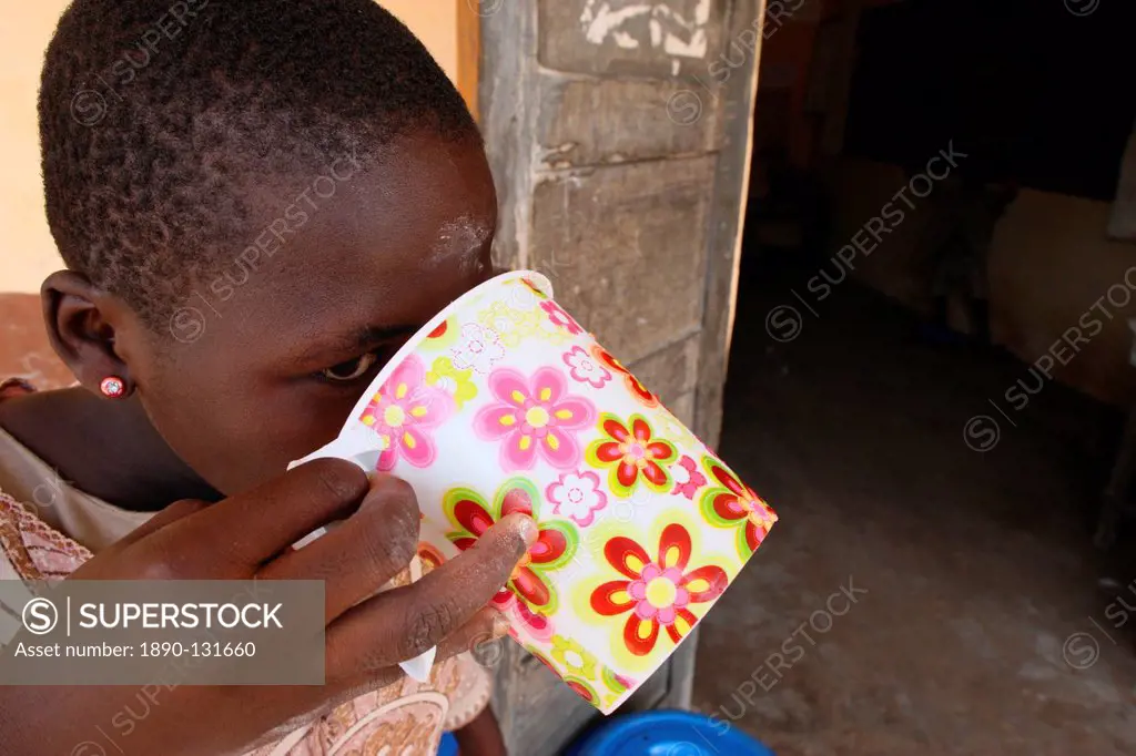 Girl drinking water, Lome, Togo, West Africa, Africa
