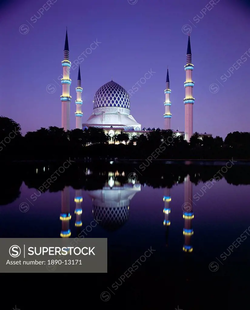 Reflection in tranquil water of the dome and minarets of the Sultan Salahuddin Abdul Aziz Shah Mosque, the largest Islamic mosque in Southeast Asia, S...