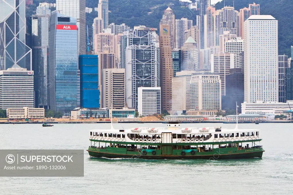 Star ferry crosses Victoria Harbour with Hong Kong Island skyline behind, Hong Kong, China, Asia