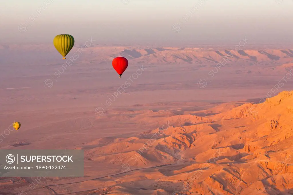 Hot air balloons suspended over the Theban hills of Luxor and the Valley of the Queens at sunrise, Thebes, UNESCO World Heritage Site, Egypt, North Af...