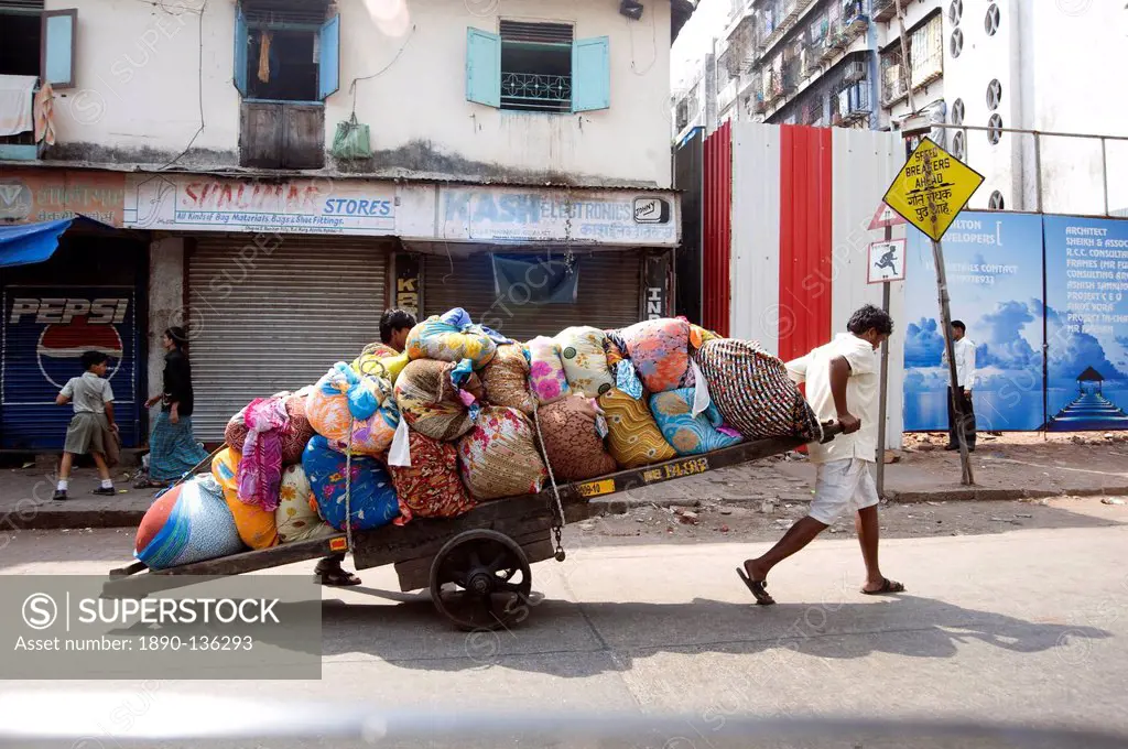 Laundrymen dhobi wallahs, pulling wooden cart laden laundry from hotels for washing at Mahalaxmi dhobi ghats, Mumbai, India, Asia
