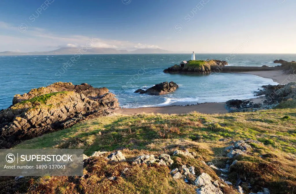 Early evening view of Pilots Cove and the beacon lighthouse Twr Bach on Llanddwyn Island, with the mountains of the Llyn Peninsula on the distant hori...