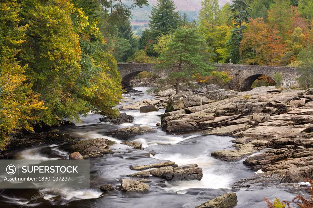 The Falls of Dochart and stone bridge surrounded by autumn foliage at Killin, Loch Lomond and The Trossachs National Park, Stirling, Scotland, United ...