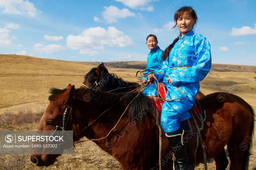 Young Mongolian women in traditional costume deel riding horses, Province of Khovd, Mongolia, Central Asia, Asia