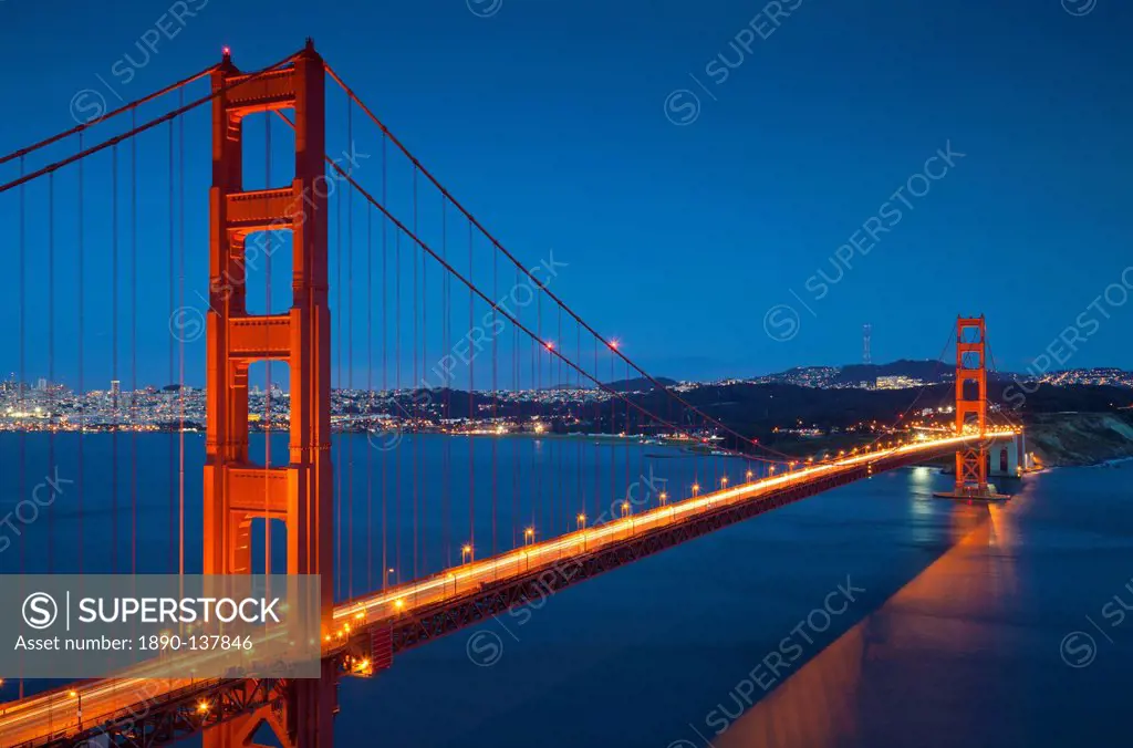 The Golden Gate Bridge, from the Marin Headlands at night with the city of San Francisco in the background and traffic light trails across the bridge,...