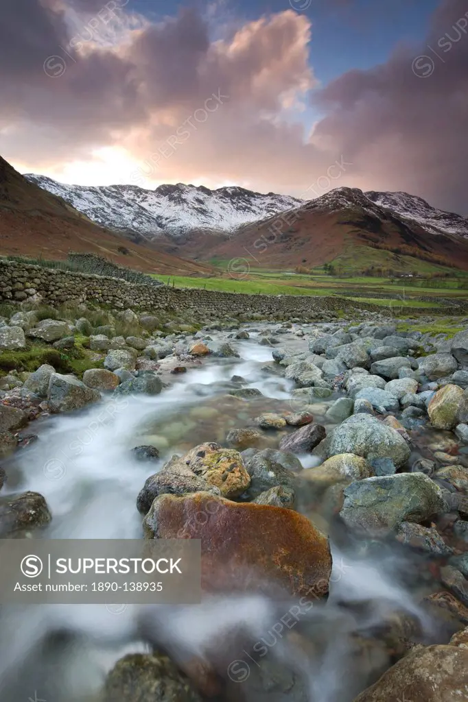 Redacre Gill river tumbling over rocks towards the snow capped mountains surrounding Great Langdale, Lake District National Park, Cumbria, England, Un...