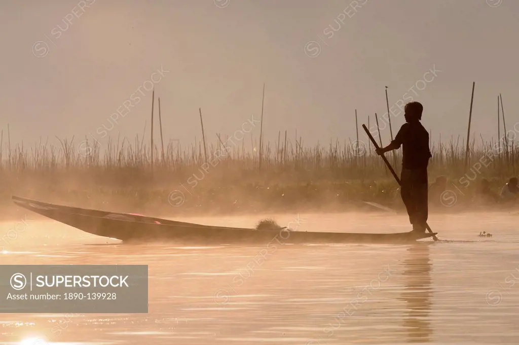 Man rowing his little rowing boat at sunrise on Inle Lake, Shan States, Myanmar, Asia