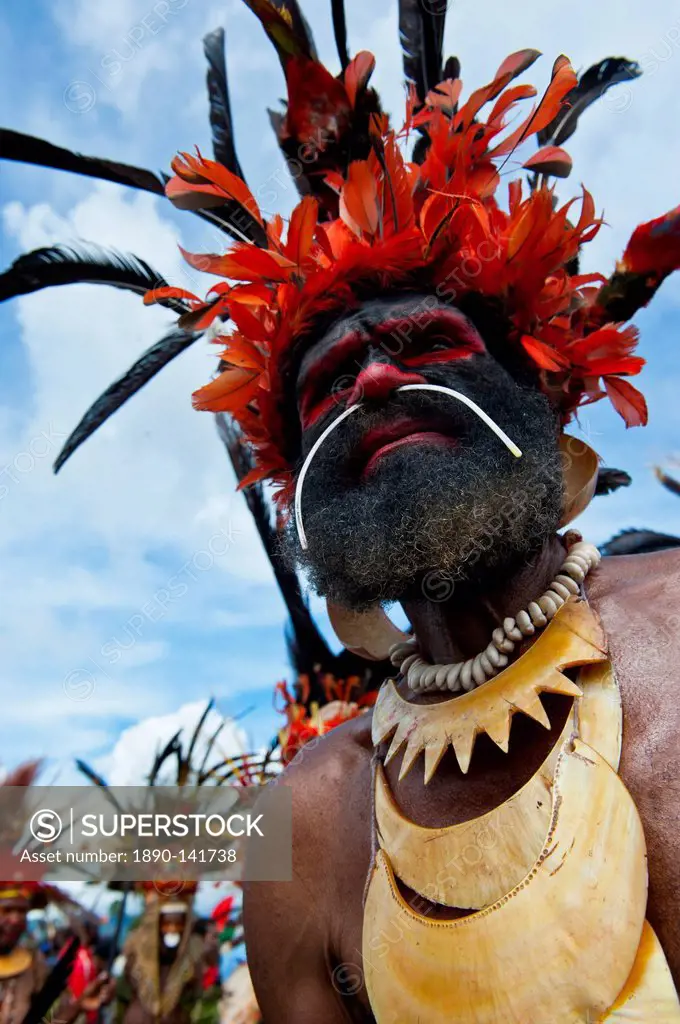 Colourfully dressed and face painted local tribesman celebrating the traditional Sing Sing in the Highlands of Papua New Guinea, Pacific