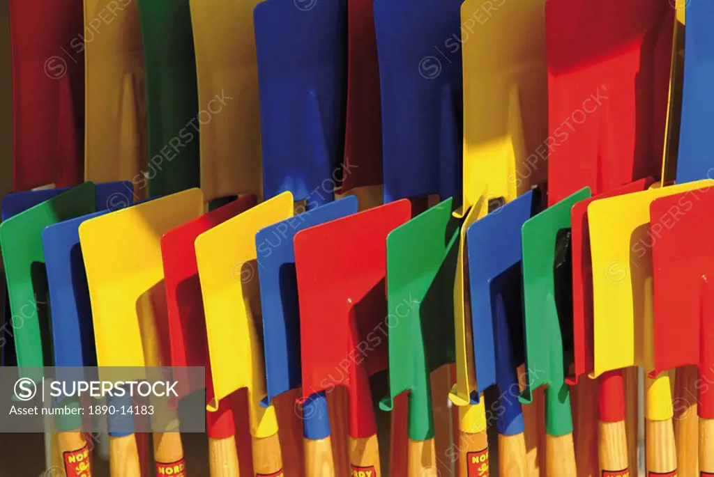 Multi coloured spades on sale at a beach shop on the Planche, Deauville, Calvados, Normandy, France, Europe