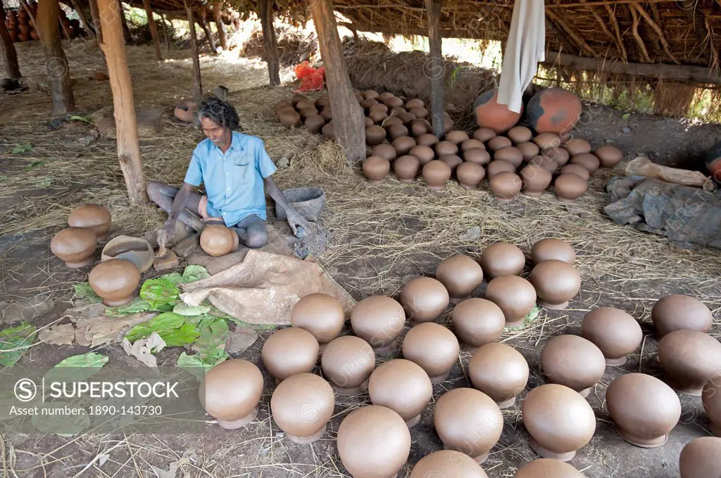 Potter making clay water pots in a thatched shelter in a rural village, near Rayagada, Orissa, India, Asia