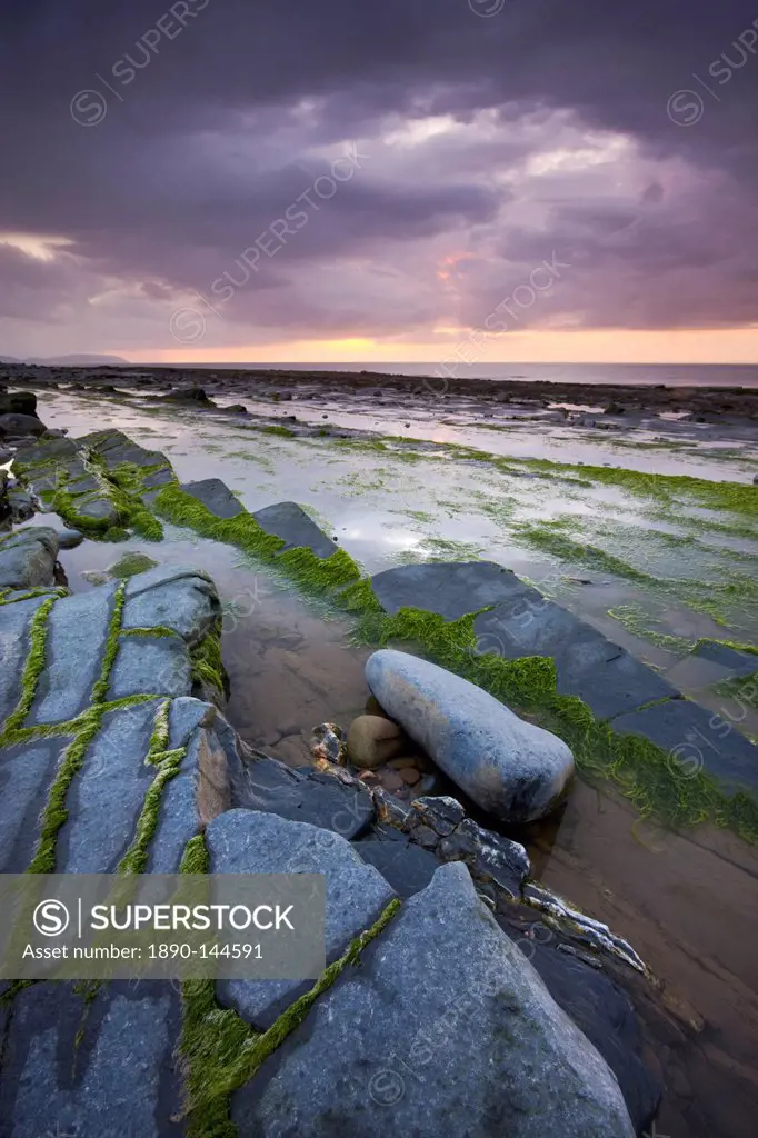Stormy sunset over the Bristol Channel, viewed from the rocky shores of Kilve Beach, Somerset, England, United Kingdom, Europe