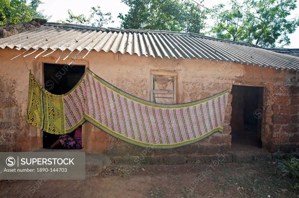 Cotton sari being hung out to dry across village house wall, rural Orissa, India, Asia