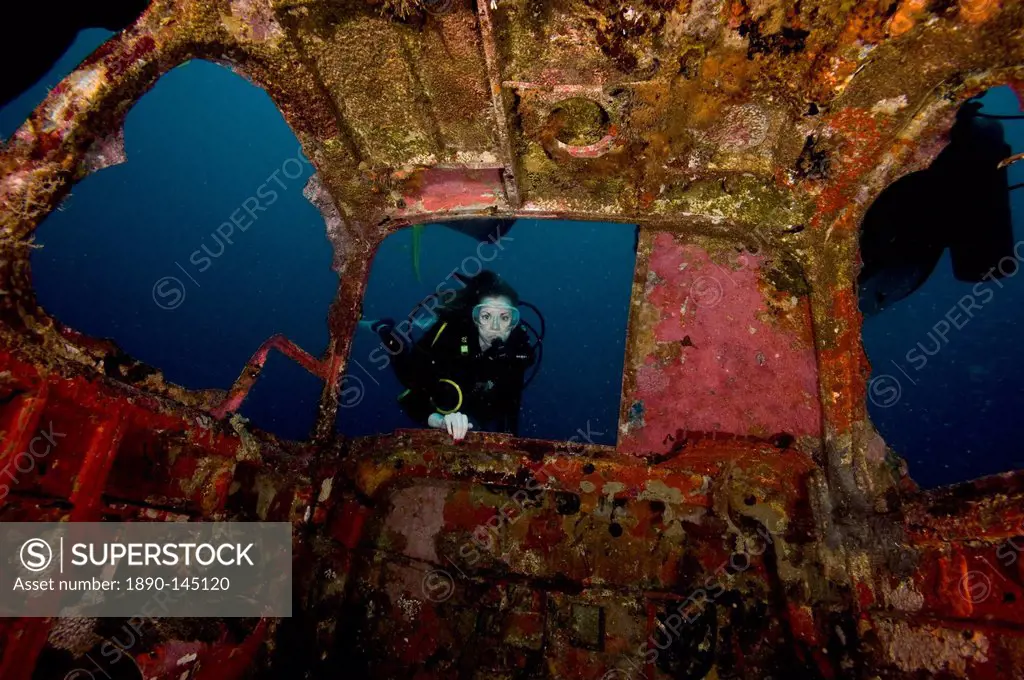 Diver entering the front window of a four seater plane wreck, Philippines, Southeast Asia, Asia