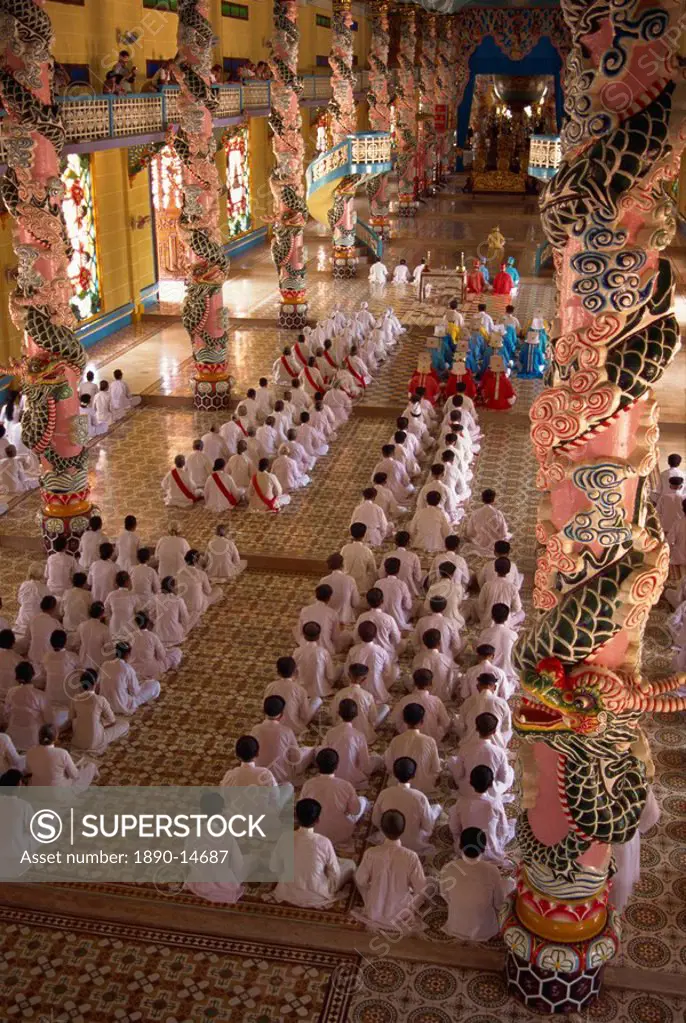 Rows of monks at prayer inside a temple of the Caodai religious sect, at Tay Ninh, Vietnam, Indochina, Southeast Asia, Asia