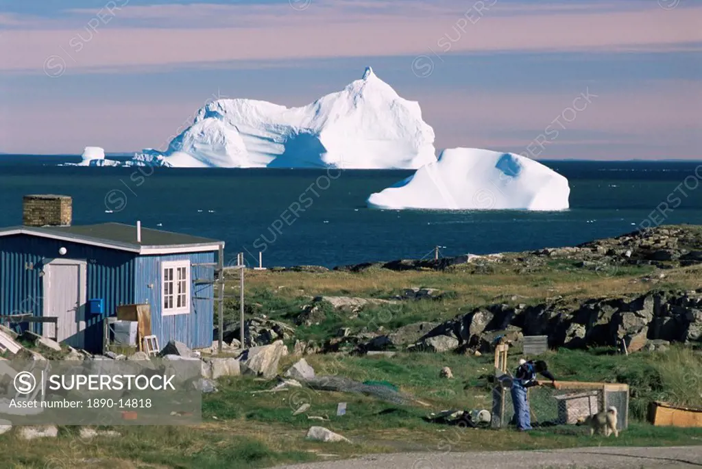 Painted wooden fisherman´s house in front of icebergs in Disko Bay, Qeqertarsuaq Godhavn, Disko Island, west coast, Greenland, Polar Regions
