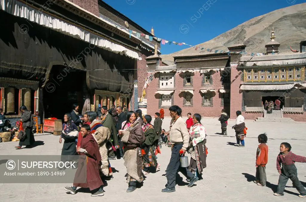 Pilgrims in monastery courtyard,. Sakya, Tibet, China, Asia