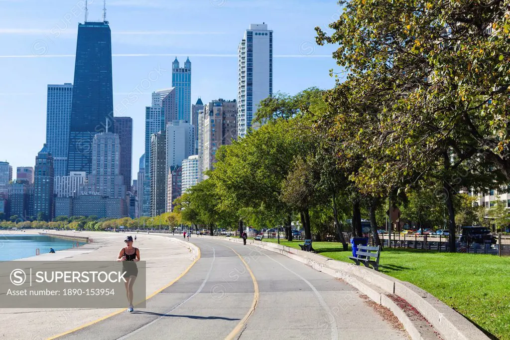 Jogger on North Avenue Beach with John Hancock Center and city skyline behind, Chicago, Illinois, United States of America, North America