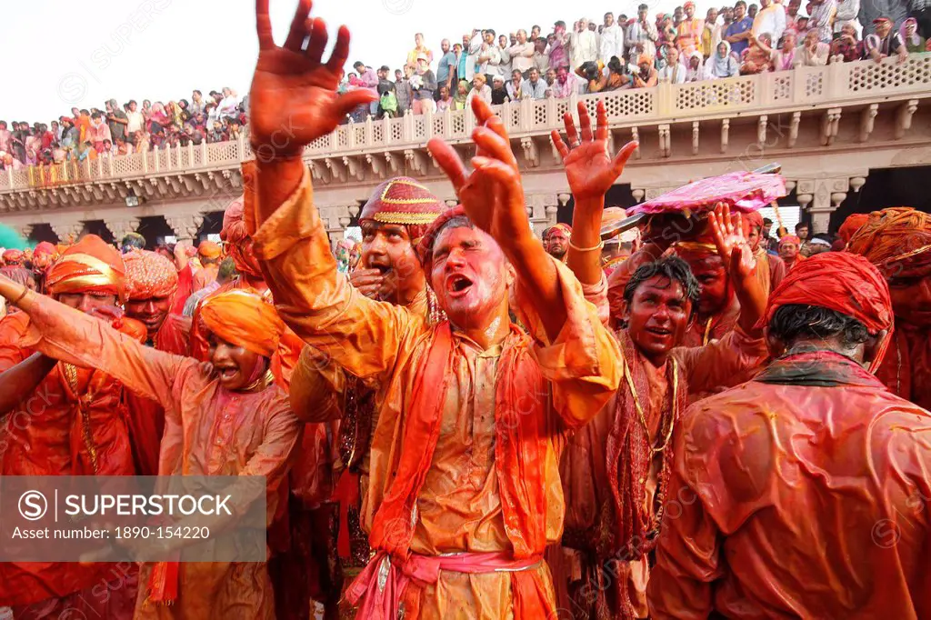 Barsana villagers celebrating Holi in Nandgaon, taunting Nandgaon villagers who throw colored fluids over them, Nandgaon, Uttar Pradesh, India, Asia