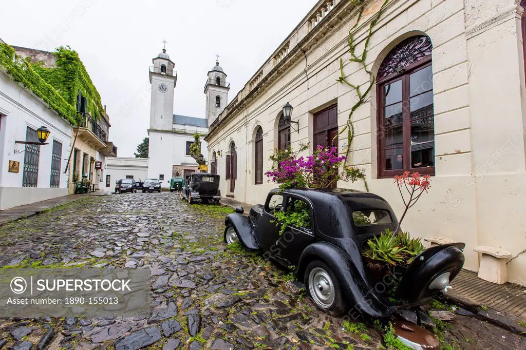 Old car turned into planter on cobblestone street in Colonia del Sacramento, Uruguay, South America