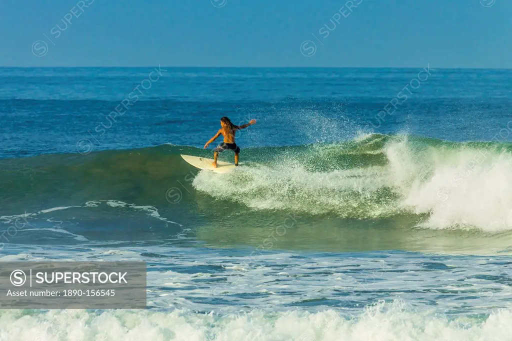 Surfer riding a wave at popular Playa Guiones surf beach, Nosara, Nicoya Peninsula, Guanacaste Province, Costa Rica, Central America