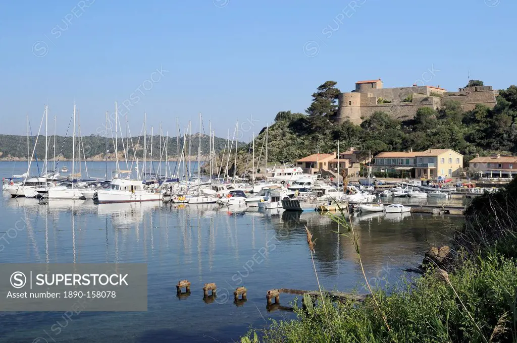 Sailing yachts and other boats moored at Port Cros Island in front of Fort de l'Eminence castle, Hyeres archipelago, Var, Provence, Cote d'Azur, Franc...
