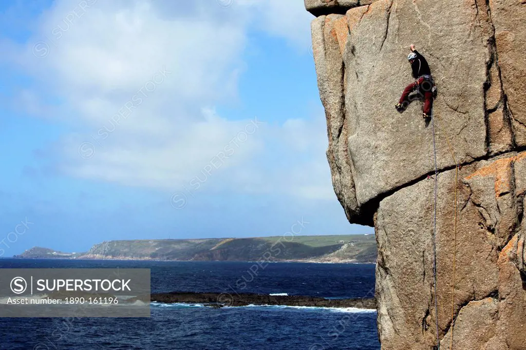 A climber scales cliffs at Sennen Cove, Cornwall, England, United Kingdom, Europe