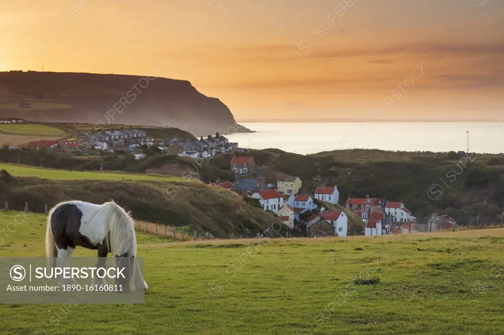 Staithes fishing village and distant Boulby Cliffs on the North Yorkshire Heritage Coastline, Staithes, Yorkshire, England, United Kingdom, Europe