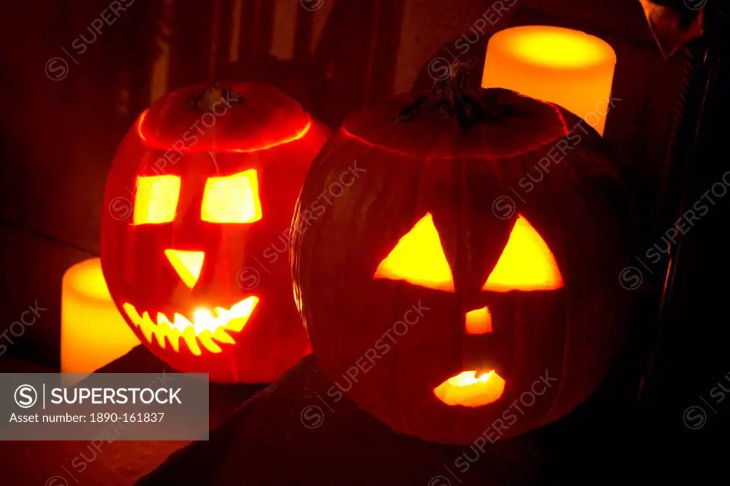 Two jack o'lanterns on the steps of a New York brownstone on Halloween night, Manhattan, New York City, United States of America, North America