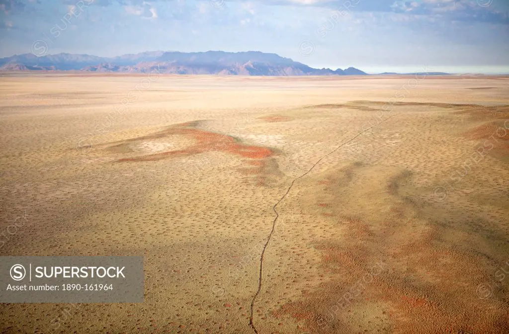 Aerial view from hot air balloon over magnificent desert landscape of sand dunes, mountains and Fairy Circles, Namib Rand game reserve Namib Naukluft ...