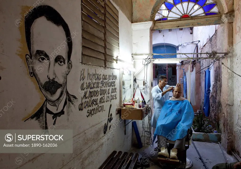 Man having haircut in backstreet barber shop, Havana Viejo, Havana, Cuba, West Indies, Central America